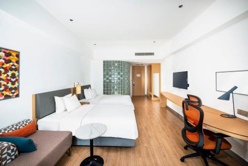 a hotel room with a large bed and a desk at Holiday Inn Express Haikou West Coast by IHG in Haikou