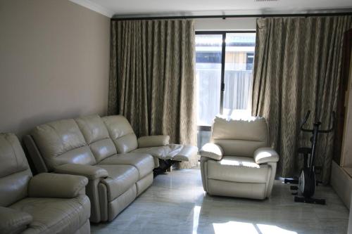 a living room with a couch and a chair at Close to Wild Life Park and shopping, Cosy living in West Swan
