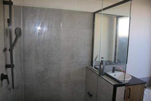 a bathroom with a shower with a sink and a mirror at Close to Wild Life Park and shopping, Cosy living in West Swan