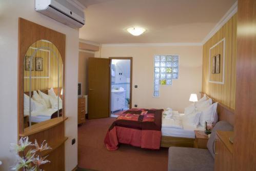 a hotel room with a bed and a bathroom at Hotel Isabell Győr in Győr