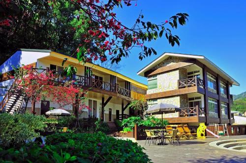 a building with tables and chairs in front of it at Ci Meng Rou Resort Villa in Dahu
