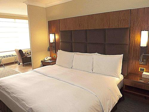 a large white bed in a hotel room at Swissotel Quito in Quito