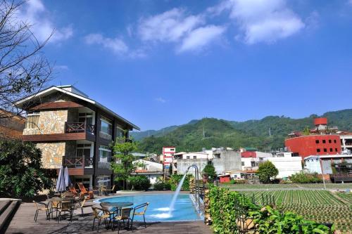 a resort with a pool and tables and chairs at Ci Meng Rou Resort Villa in Dahu