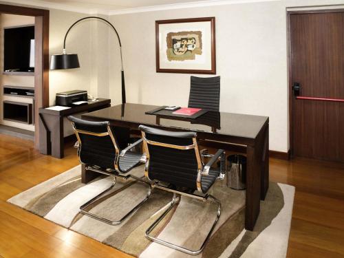 an office with a desk and three chairs at Swissotel Quito in Quito