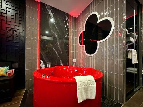 胡志明市Cupid Hotel 3的浴室里有一个红色的浴缸，墙壁是黑白的