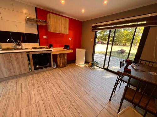 a kitchen with red walls and a wooden floor at Cabaña familiar Huilo huilo in Choshuenco