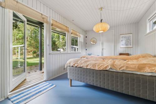 a bedroom with a large bed and a window at Renovated Holiday Home Near Water And Nature in Lundø