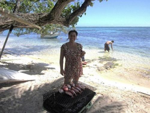a woman standing on a beach with a basket of eggs at Fare Maheata in Pihaena