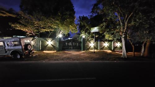 a car parked in front of a fence at night at SPM Residency, From Live2Travel Group. in Masinagudi