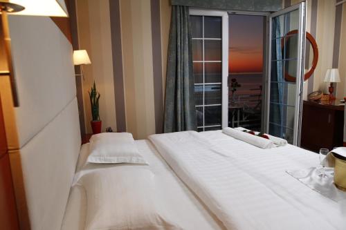 Habitación de hotel con 2 camas y ventana grande. en Bel Conti Hotel en Durrës