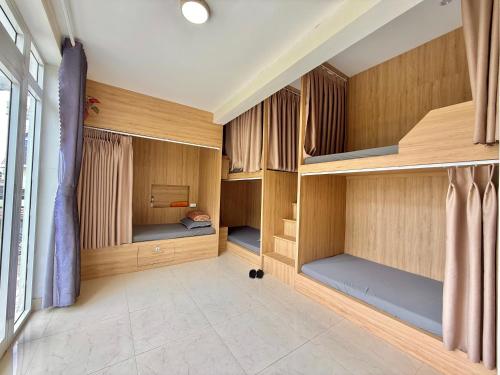 a room with wooden walls and bunk beds at Cloud River Homestay in Da Lat