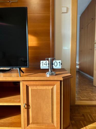 a television sitting on top of a wooden cabinet at Ruhige, klimatisierte Wohnung nahe Zentrum & Bahnhof in Sankt Pölten