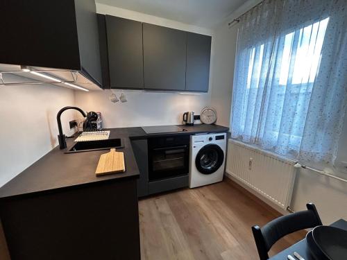 a kitchen with a washer and dryer in a room at Ruhige, klimatisierte Wohnung nahe Zentrum & Bahnhof in Sankt Pölten