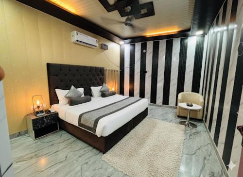 a bedroom with a large bed and a chair at The Family Palace in Ayodhya