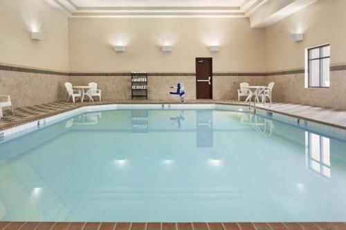 a large swimming pool with blue water in a building at Country Inn & Suites by Radisson, Lincoln North Hotel and Conference Center, NE in Lincoln