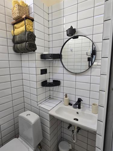 Un baño con inodoro, lavabo y espejo. en Studio in old town tbilisi, en Tiflis