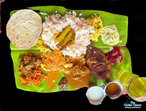 a green plate of food with rice and vegetables on it at The Oyster Opera in Trikarpur