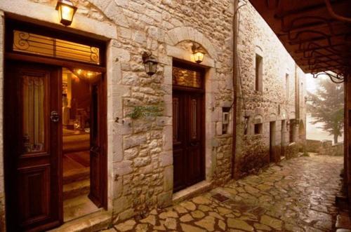an old stone building with two doors on a street at Guesthouse Theonimfi in Dimitsana