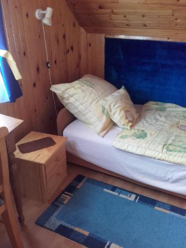 a small bedroom with a bed and a night stand at János Nyaraló in Balatonmáriafürdő