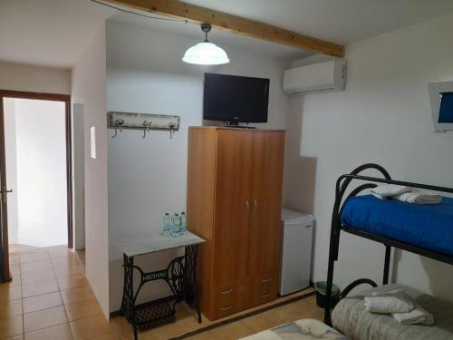 a room with a bedroom with a bed and a television at La Locanda Ta Nonna Tuta in Parabita