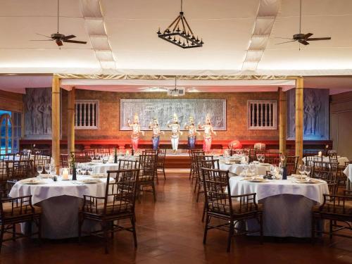 a banquet hall with a group of dancers on the stage at Raffles Grand Hotel d'Angkor in Siem Reap