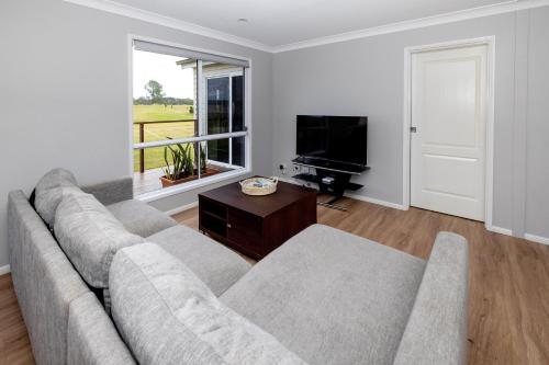 a living room with a couch and a television at BIG4 Big River Holiday Park in Seelands
