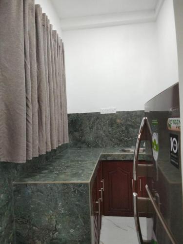 a kitchen with a marble counter top and curtains at Queen Villa in Bentota