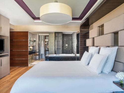 a bedroom with a large bed and a bathroom at Swissotel The Bosphorus Istanbul in Istanbul