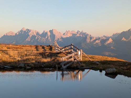 a bridge over a body of water with mountains in the background at Residence Aichner in Brunico