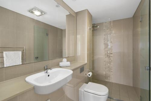 a bathroom with a sink and a toilet and a mirror at Mosman Moments Elevated Living on the Harbour - RAG05 in Sydney