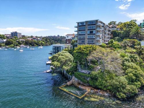 an island in the water with trees and buildings at Mosman Moments Elevated Living on the Harbour - RAG05 in Sydney