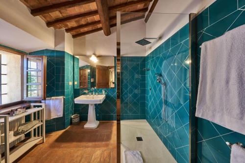 a bathroom with a sink and a shower with blue tiles at Villa Isaia 31 in Monteriggioni