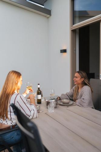 two women sitting at a table drinking wine at Kooparc vakantiepark in Giesbeek