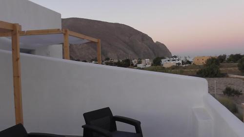 a black chair sitting on a balcony with a mountain at Daylight Hotel in Perissa