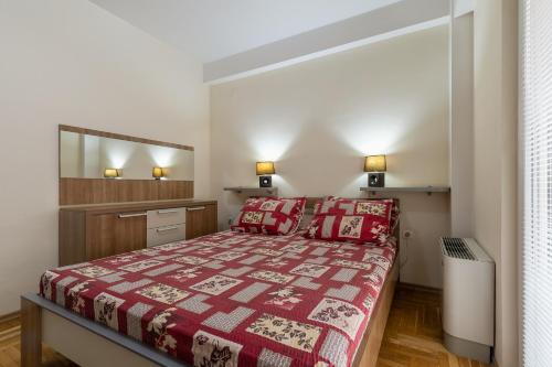 a bedroom with a bed with a red bedspread at APT Near Millenium Cross,Clinical Center Mother Teresa, City-Center,Free Parking in Skopje