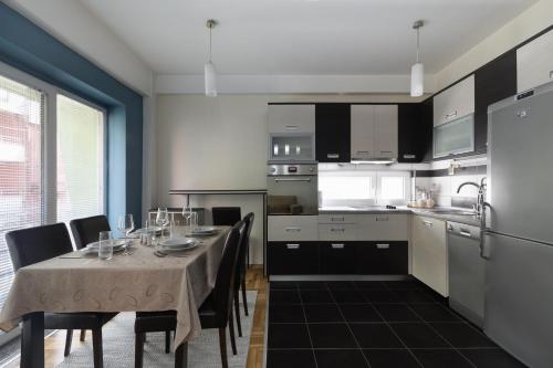 a kitchen with a table with chairs and a dining room at APT Near Millenium Cross,Clinical Center Mother Teresa, City-Center,Free Parking in Skopje