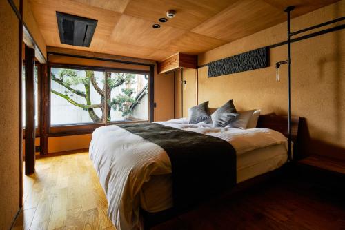 une chambre avec un grand lit avec une grande fenêtre dans l'établissement Rinn Kishoan, à Kyoto