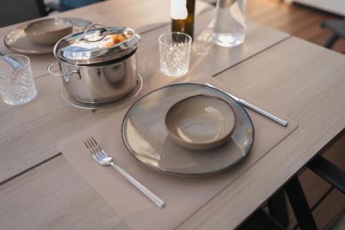 a table with plates and utensils and a pot on it at Kooparc vakantiepark in Giesbeek