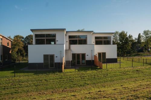 a house in the middle of a field at Kooparc vakantiepark in Giesbeek