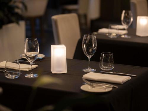 a table with wine glasses and a candle on it at Swissotel Sydney in Sydney