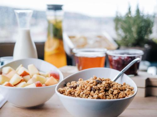 two bowls of cereal and fruit on a table at Swissotel Sydney in Sydney