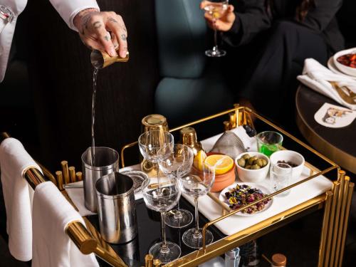 a person pouring wine into a tray of wine glasses at Swissotel Sydney in Sydney