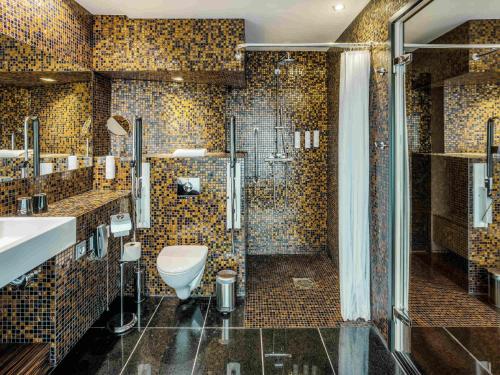 a bathroom with a toilet and a shower at Swissotel Tallinn in Tallinn