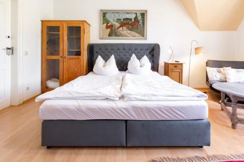 Un dormitorio con una cama grande con sábanas blancas. en Kunstloft, en Marienberg
