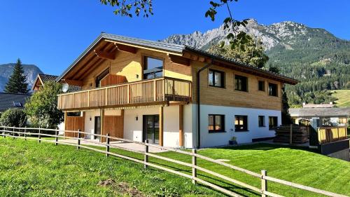 a house on a hill with a fence at dein Dahoam Boutique Appartements in Gröbming