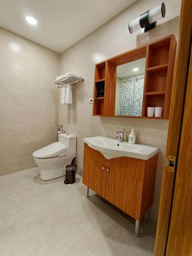 a bathroom with a toilet and a sink and a mirror at Mille Rich Hotel in Taitung City