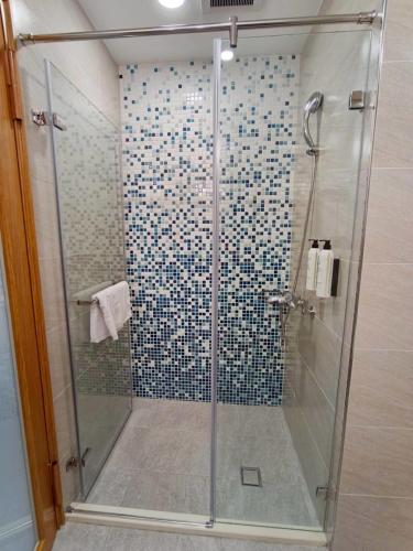 a shower with a glass door in a bathroom at Mille Rich Hotel in Taitung City