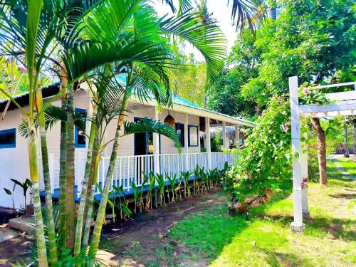 a house with tables and chairs in front of it at Oasi Bungalow Gili Air in Gili Islands