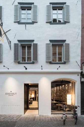 a white building with windows and a bike parked outside at Eisenhut Boutique Hotel in Bolzano