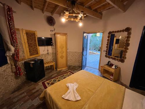 a room with a bed and a mirror and a door at Bait Gamal Siwa بيت جمال سيوة in Siwa